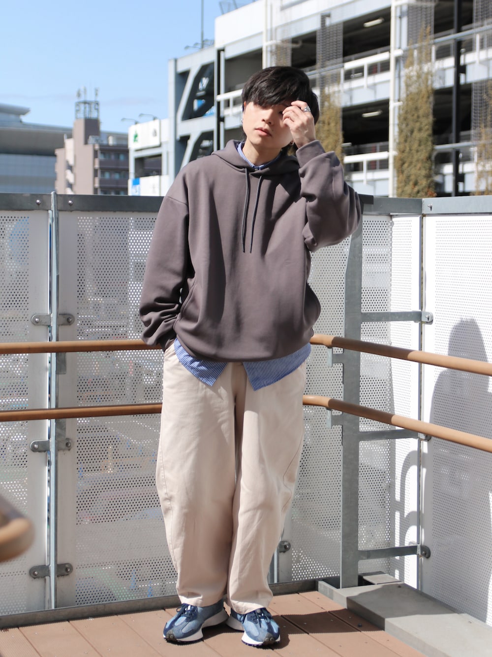 ブルー系のシャツ/ブラウス、ベージュ系のその他パンツ、ブルー系のスニーカーを着用したメンズの春コーディネートの2枚目の写真