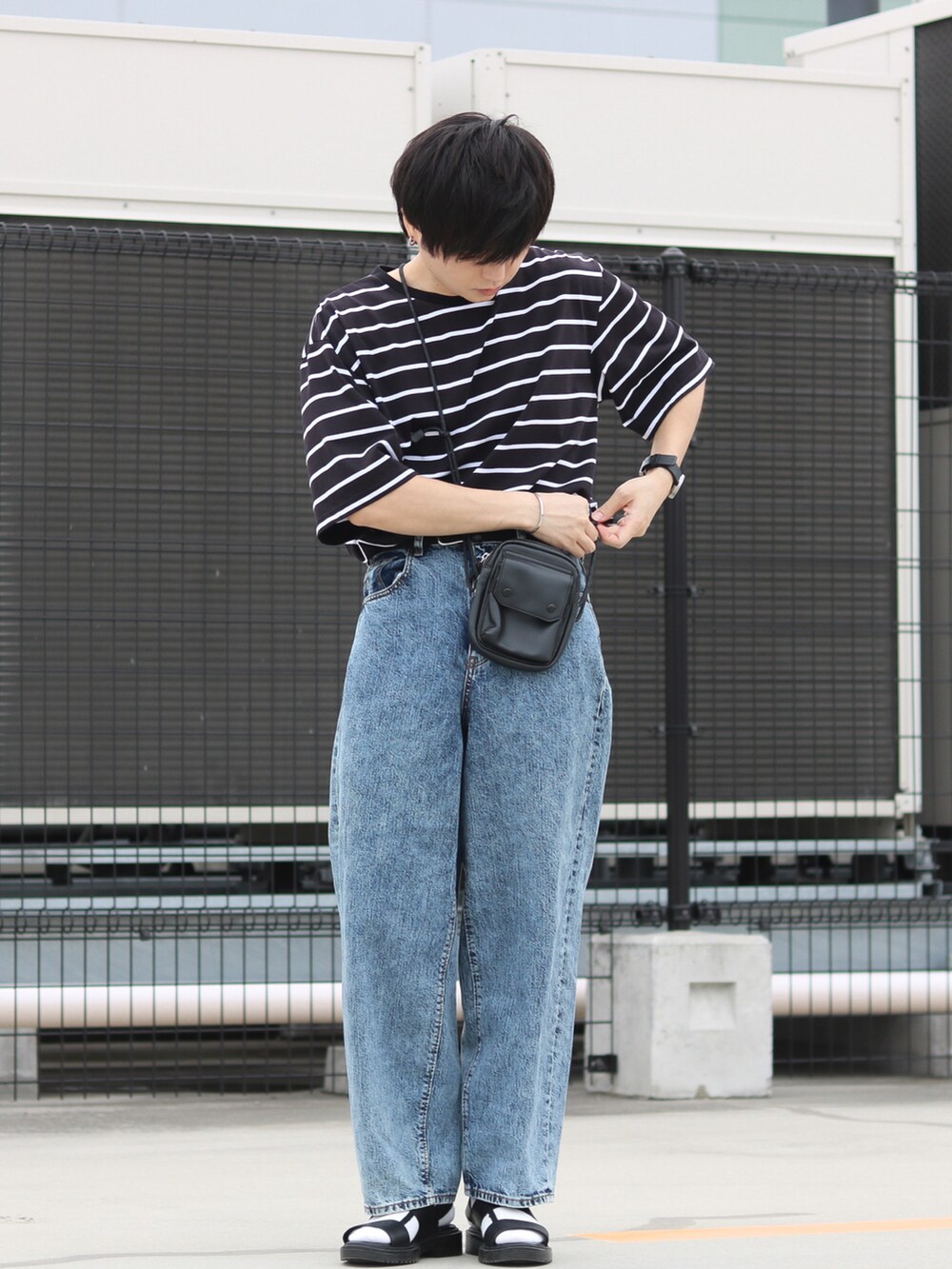 ブルー系のデニムパンツ、ホワイト系のTシャツ/カットソー、ブラック系のサンダルを着用したメンズの夏コーディネートの2枚目の写真