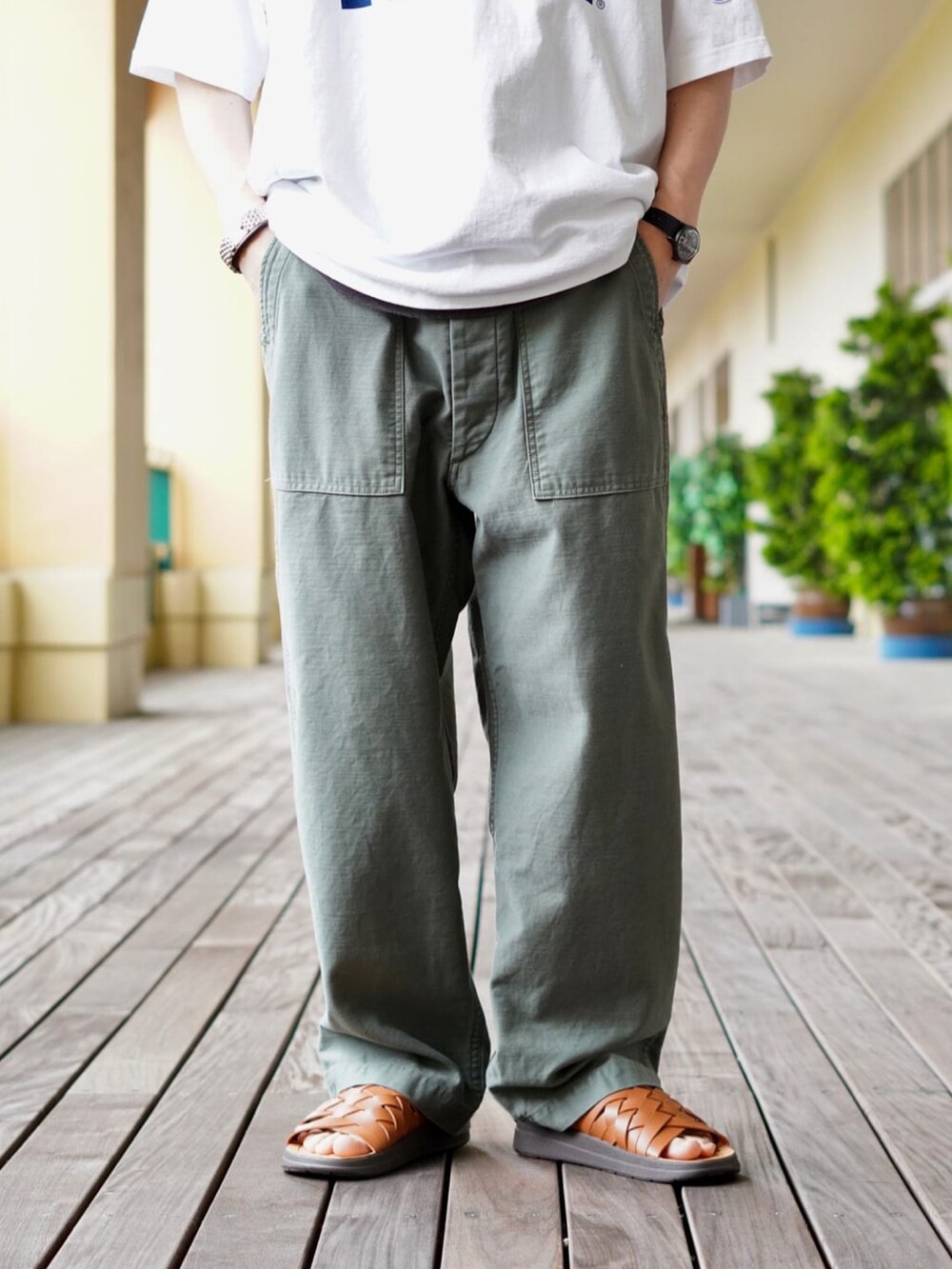 ホワイト系のTシャツ/カットソー、ブラウン系のトートバッグ、グリーン系のその他パンツを着用したメンズの春コーディネートの3枚目の写真