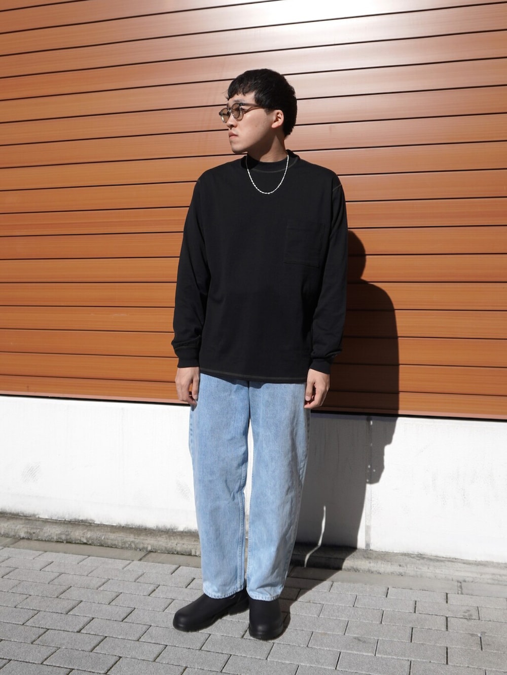 ブラック系のダウンジャケット/コート、ブラック系のTシャツ/カットソー、ブルー系のデニムパンツを着用したメンズの冬コーディネートの3枚目の写真