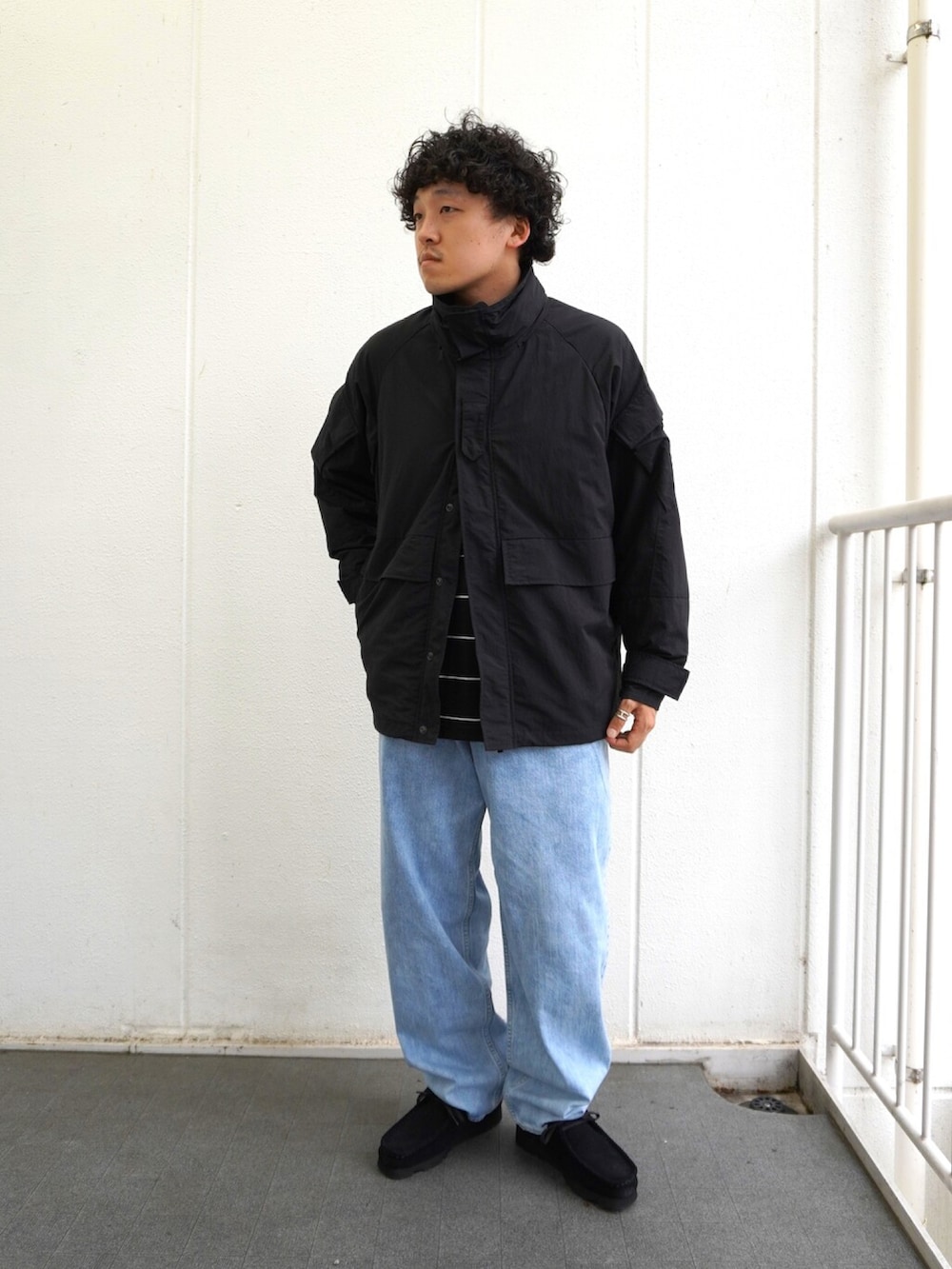 ブラック系のTシャツ/カットソー、ブラック系のショルダーバッグ、ブルー系のデニムパンツを着用したメンズの夏コーディネートの2枚目の写真