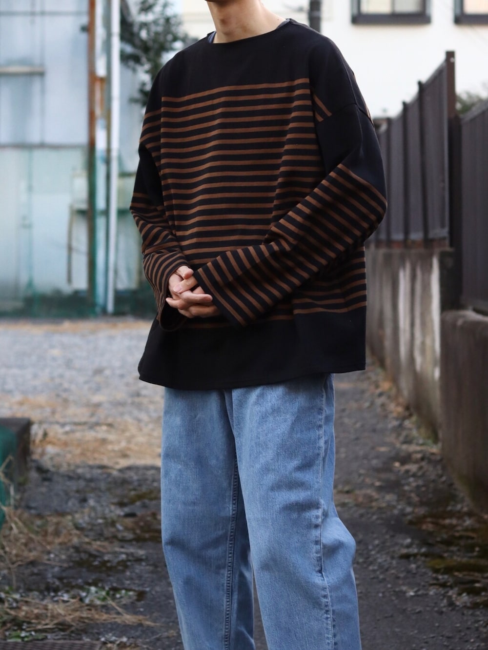 ブラック系のTシャツ/カットソー、ブラック系のベスト、ブルー系のデニムパンツを着用したメンズの冬コーディネートの3枚目の写真