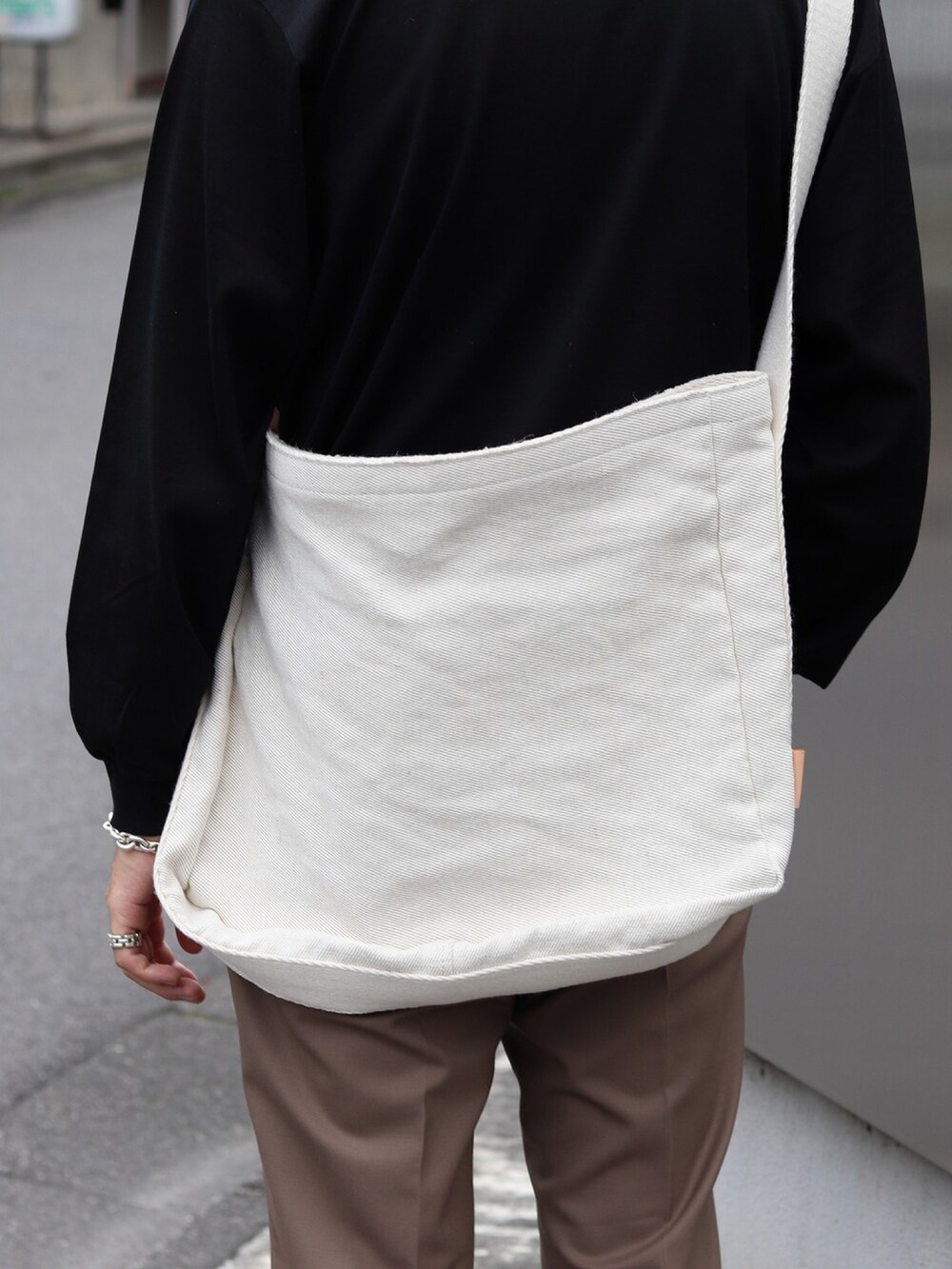 ブラック系のTシャツ/カットソー、ホワイト系のショルダーバッグを着用したメンズの秋コーディネートの3枚目の写真