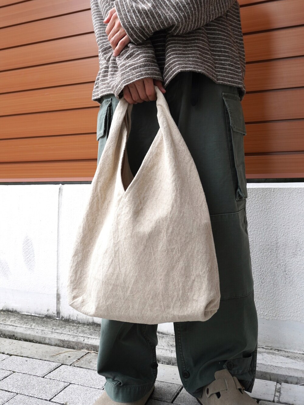 ブラウン系のTシャツ/カットソー、ベージュ系のハンドバッグ、その他のカーゴパンツを着用したメンズの秋コーディネートの3枚目の写真