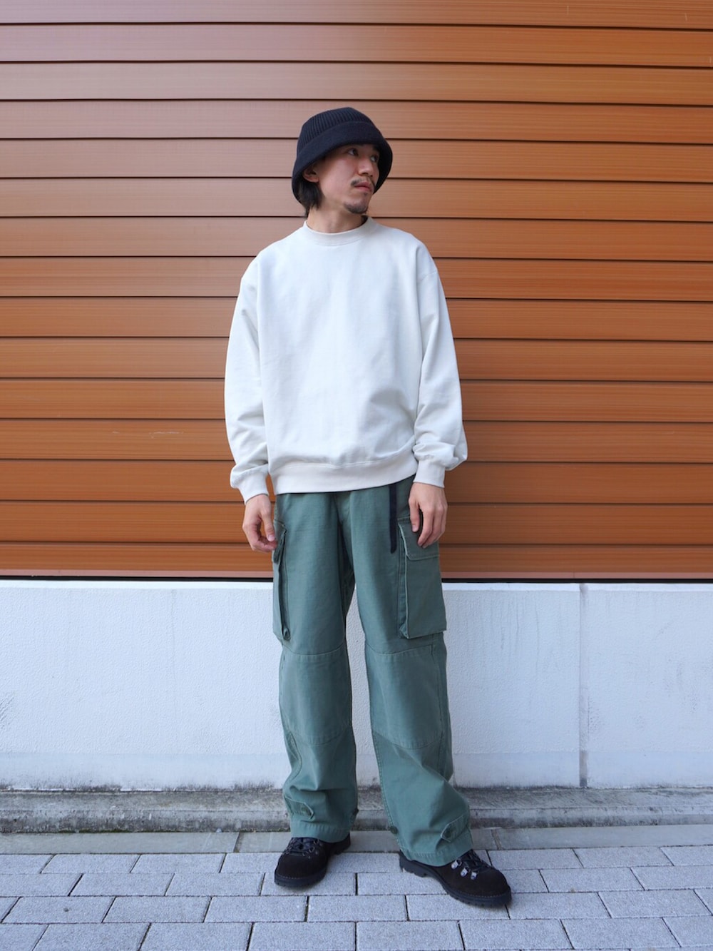 ブラック系のダウンジャケット/コート、ホワイト系のTシャツ/カットソー、グリーン系のカーゴパンツを着用したメンズの秋コーディネートの3枚目の写真