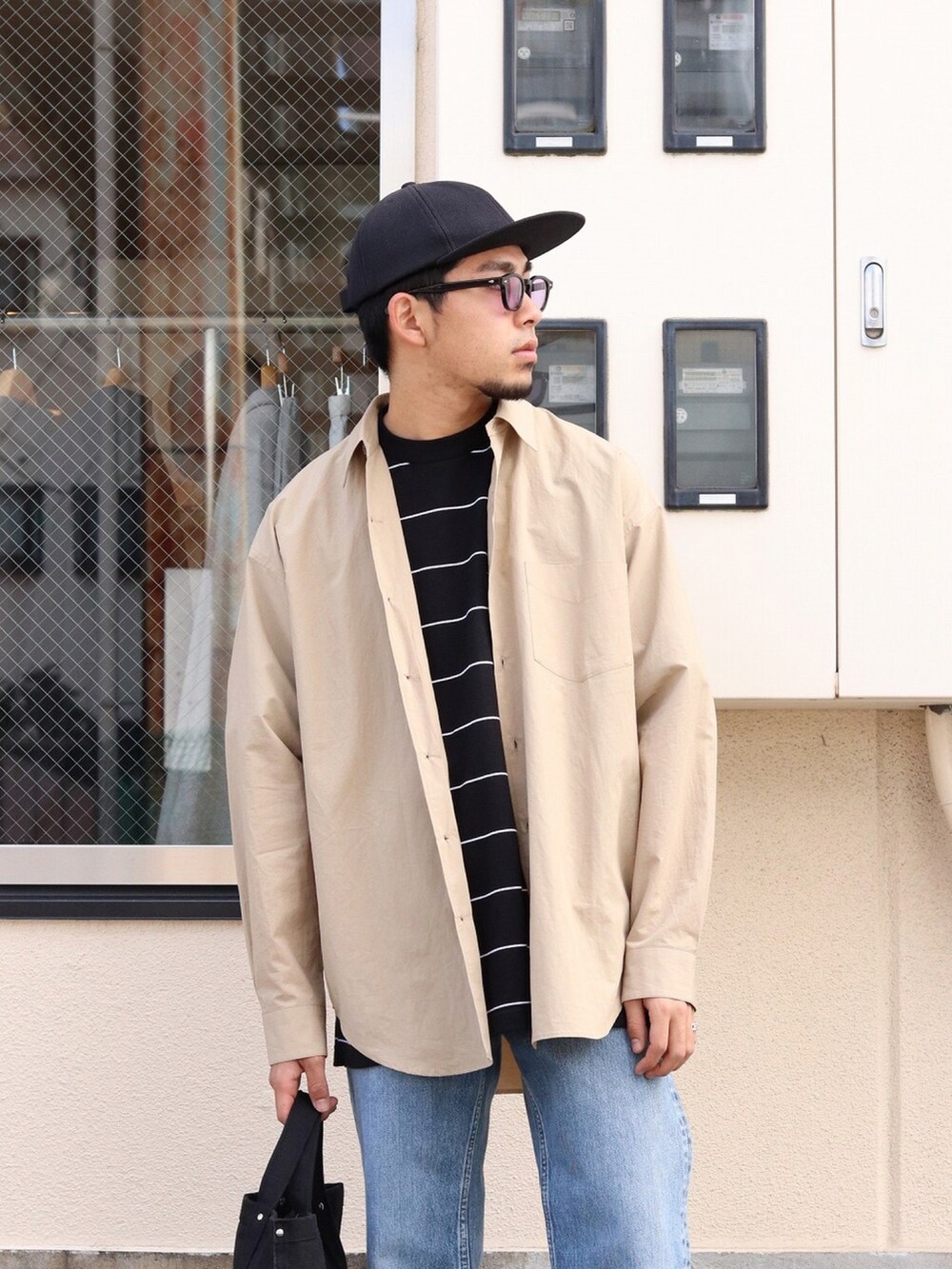 ベージュ系のシャツ/ブラウス、ブラック系のTシャツ/カットソー、ブルー系のデニムパンツを着用したメンズの春コーディネートの2枚目の写真