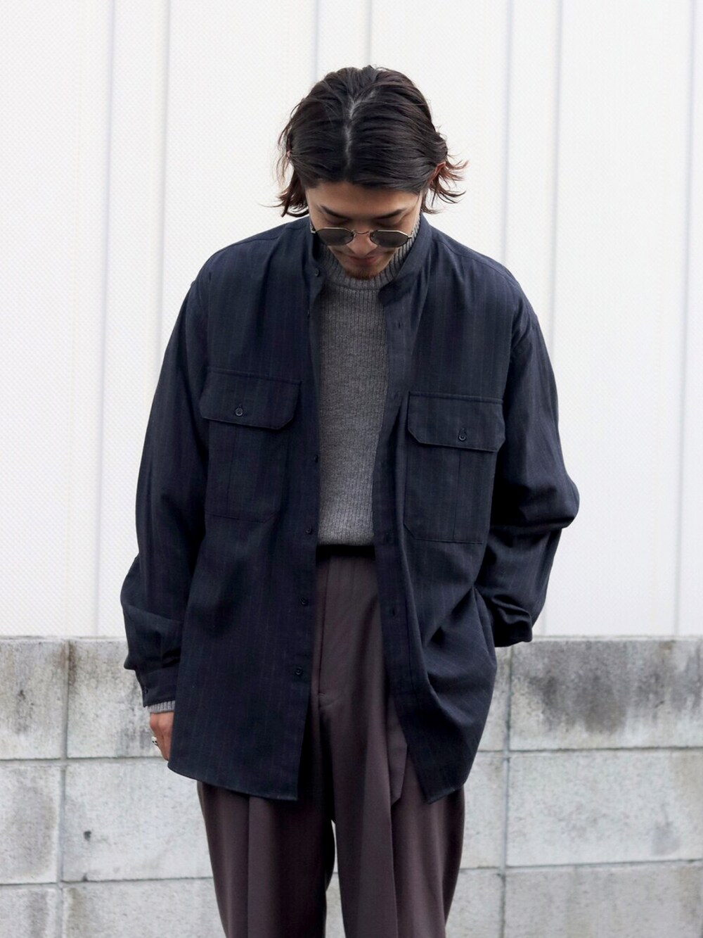 ベージュ系のニット/セーター、グレー系のシャツ/ブラウスを着用したメンズの冬コーディネートの2枚目の写真