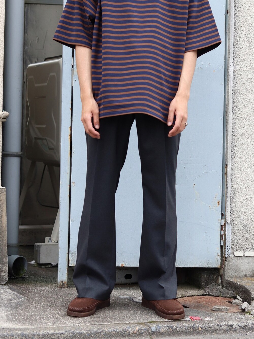 ブルー系のTシャツ/カットソー、グレー系のスラックスを着用したメンズの夏コーディネートの3枚目の写真