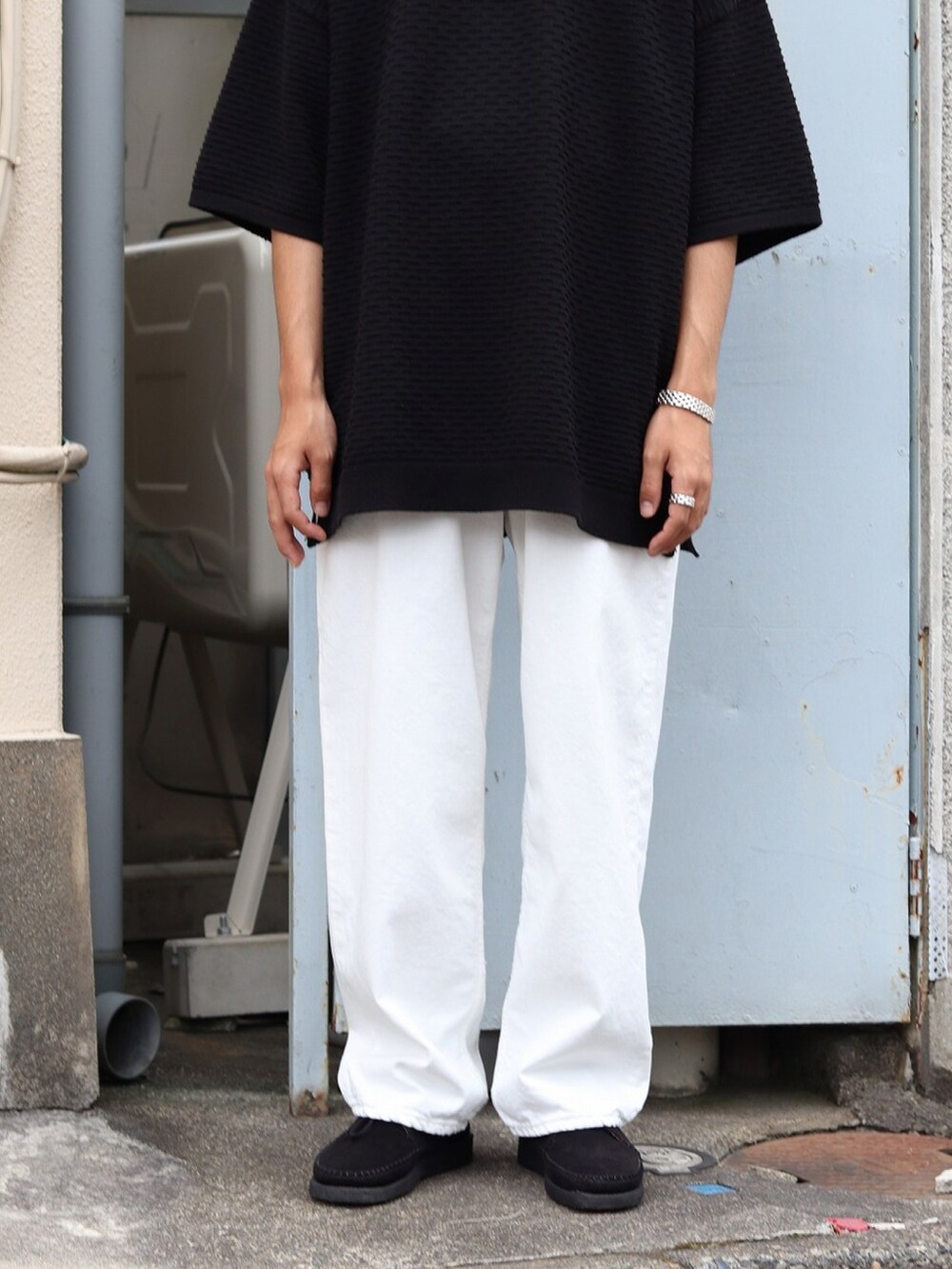 ブラック系のTシャツ/カットソー、ホワイト系のデニムパンツ、ブラック系のハットを着用したメンズの夏コーディネートの3枚目の写真