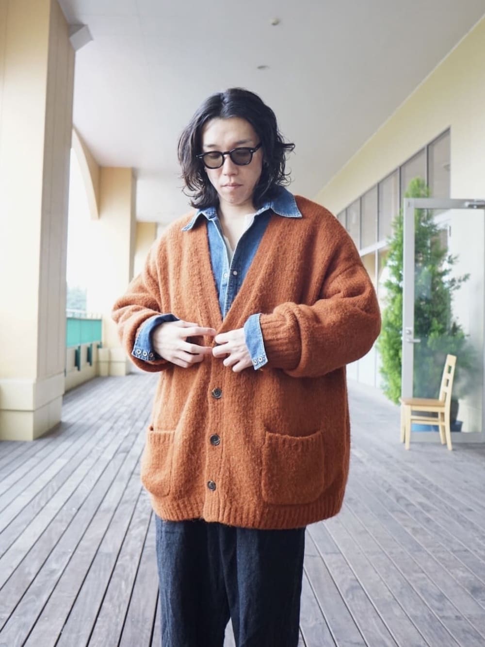 イエロー系のカーディガン/ボレロ、ブルー系のシャツ/ブラウス、ホワイト系のTシャツ/カットソーを着用したメンズの冬コーディネートの2枚目の写真