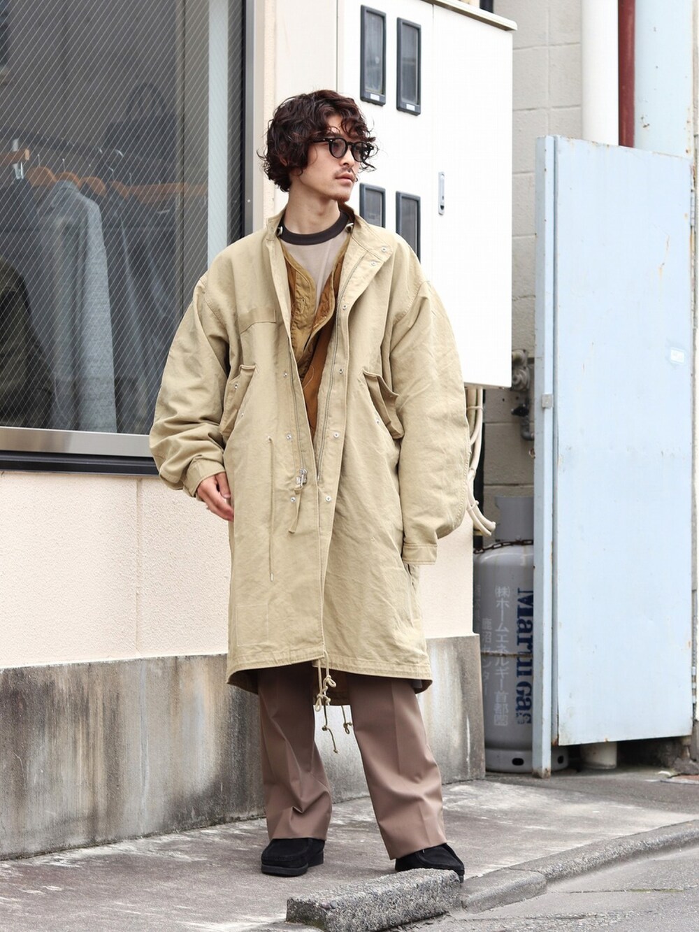 ベージュ系のTシャツ/カットソー、ブラウン系のスラックス、ブラック系のブーツを着用したメンズの秋コーディネートの3枚目の写真