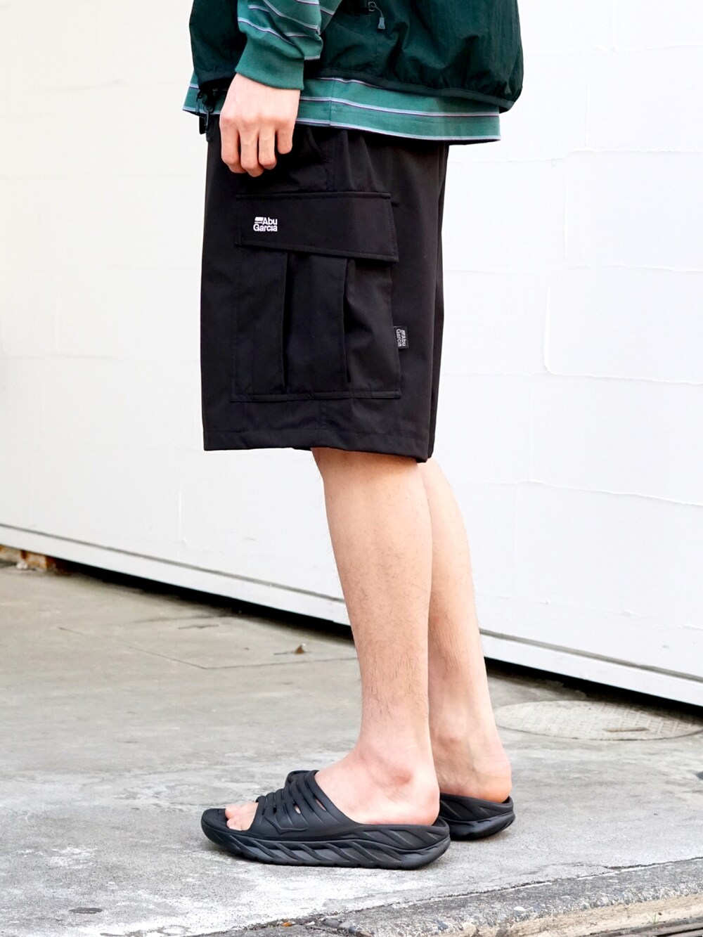 「ごきげんウィーク、休日スタイル、ゆるコーデ、DAIWAPIER39、HOKAONEONE、descendant、ABU GARCIA、別注、ARKnets、アウトドアスタイル、レイヤードスタイル、休日コーデ、春夏コーデ、ビッグシルエット、カラー×コーデ」｜「ABU GARCIAの【ONLY ARK】別注 3LAYER CARGO SHORTS（その他パンツ、ブラック系）」を使った、ARKnets STAFFさん（メンズ・179cm）の春コーディネートの3枚目の写真