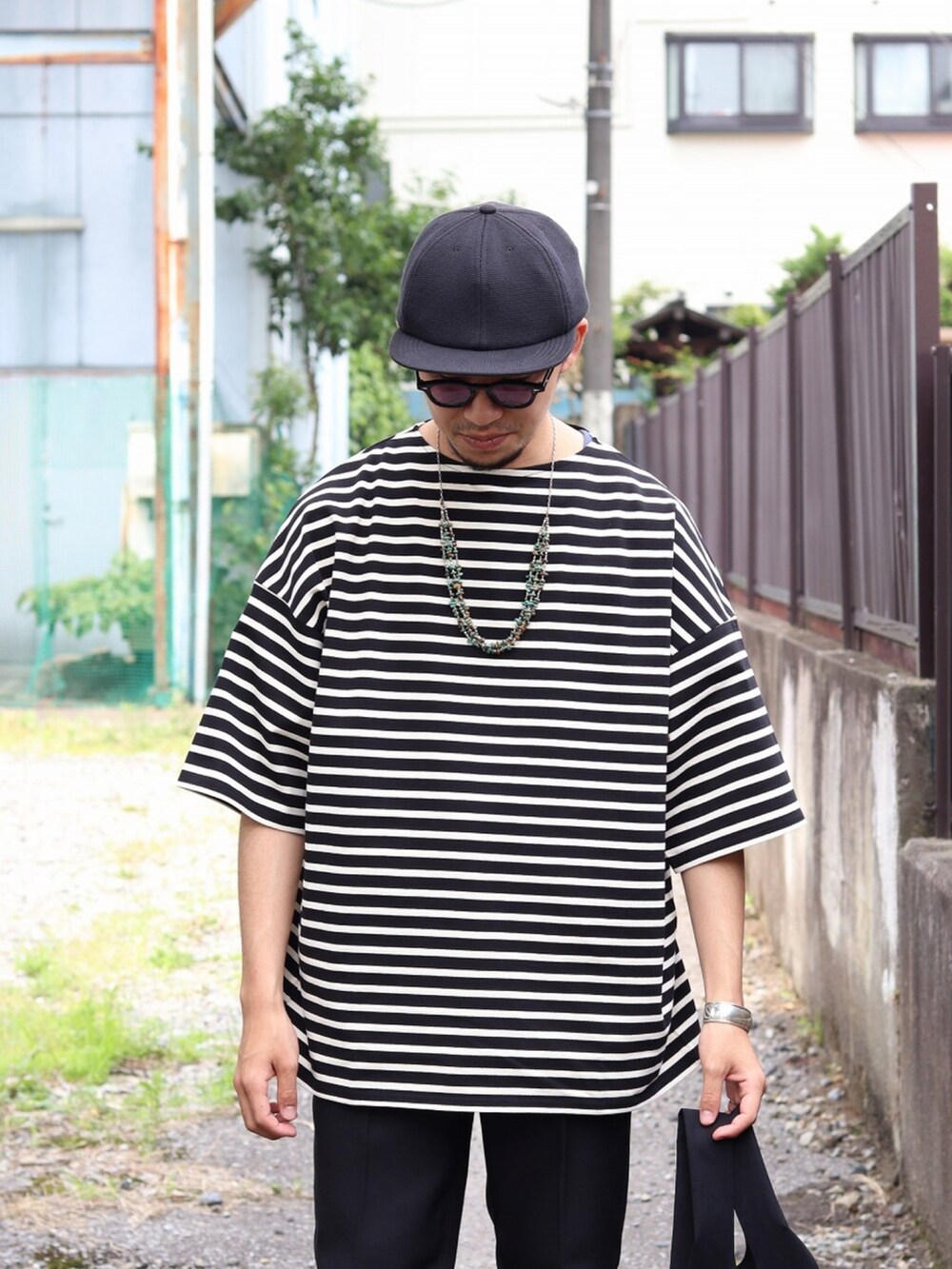 ブラック系のTシャツ/カットソー、ブラック系のトートバッグ、ブラック系のデニムパンツを着用したメンズの夏コーディネートの3枚目の写真