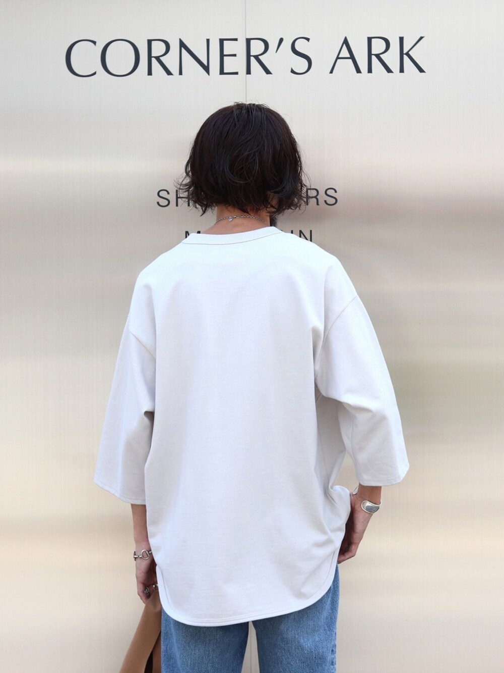 ホワイト系のTシャツ/カットソー、ブルー系のデニムパンツ、ブラウン系のトートバッグを着用したメンズの夏コーディネートの3枚目の写真