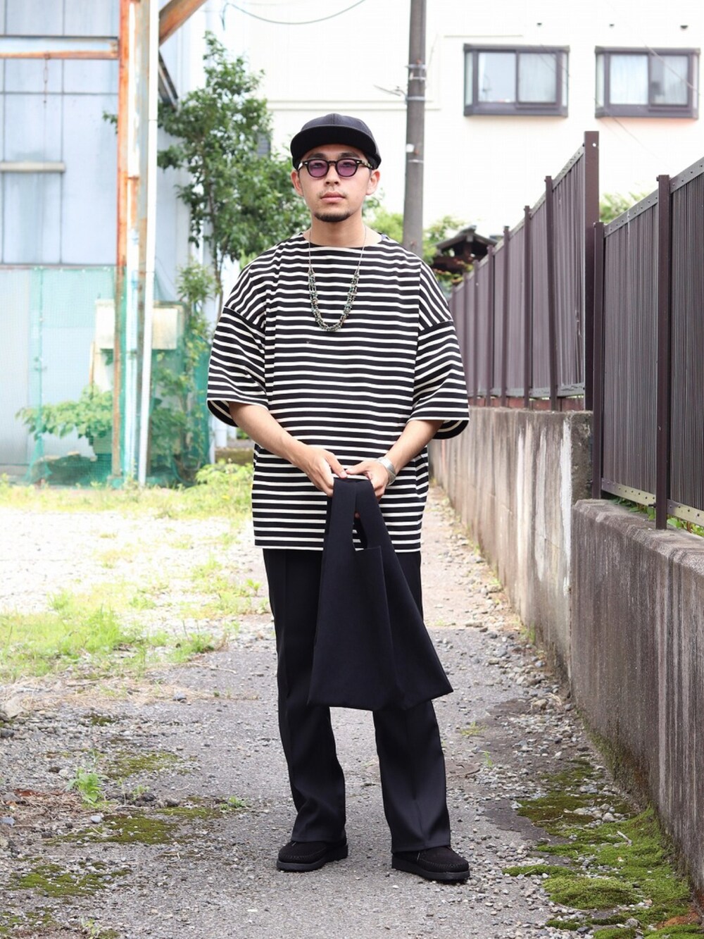 ブラック系のTシャツ/カットソー、ブラック系のトートバッグ、ブラック系のデニムパンツを着用したメンズの夏コーディネートの2枚目の写真