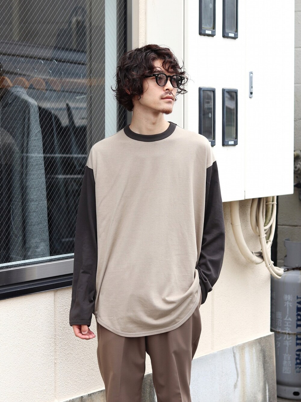 ベージュ系のTシャツ/カットソー、ブラウン系のスラックス、ブラック系のブーツを着用したメンズの秋コーディネートの2枚目の写真