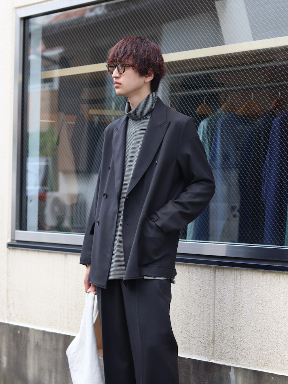 グレー系のテーラードジャケット、グレー系のニット/セーター、グレー系のスラックスを着用したメンズの秋コーディネートの2枚目の写真