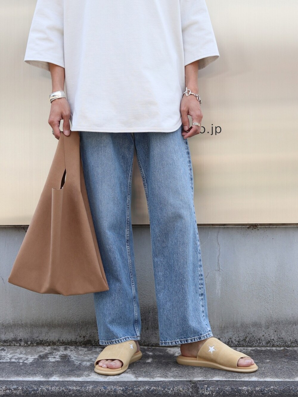 ホワイト系のTシャツ/カットソー、ブルー系のデニムパンツ、ブラウン系のトートバッグを着用したメンズの夏コーディネートの4枚目の写真