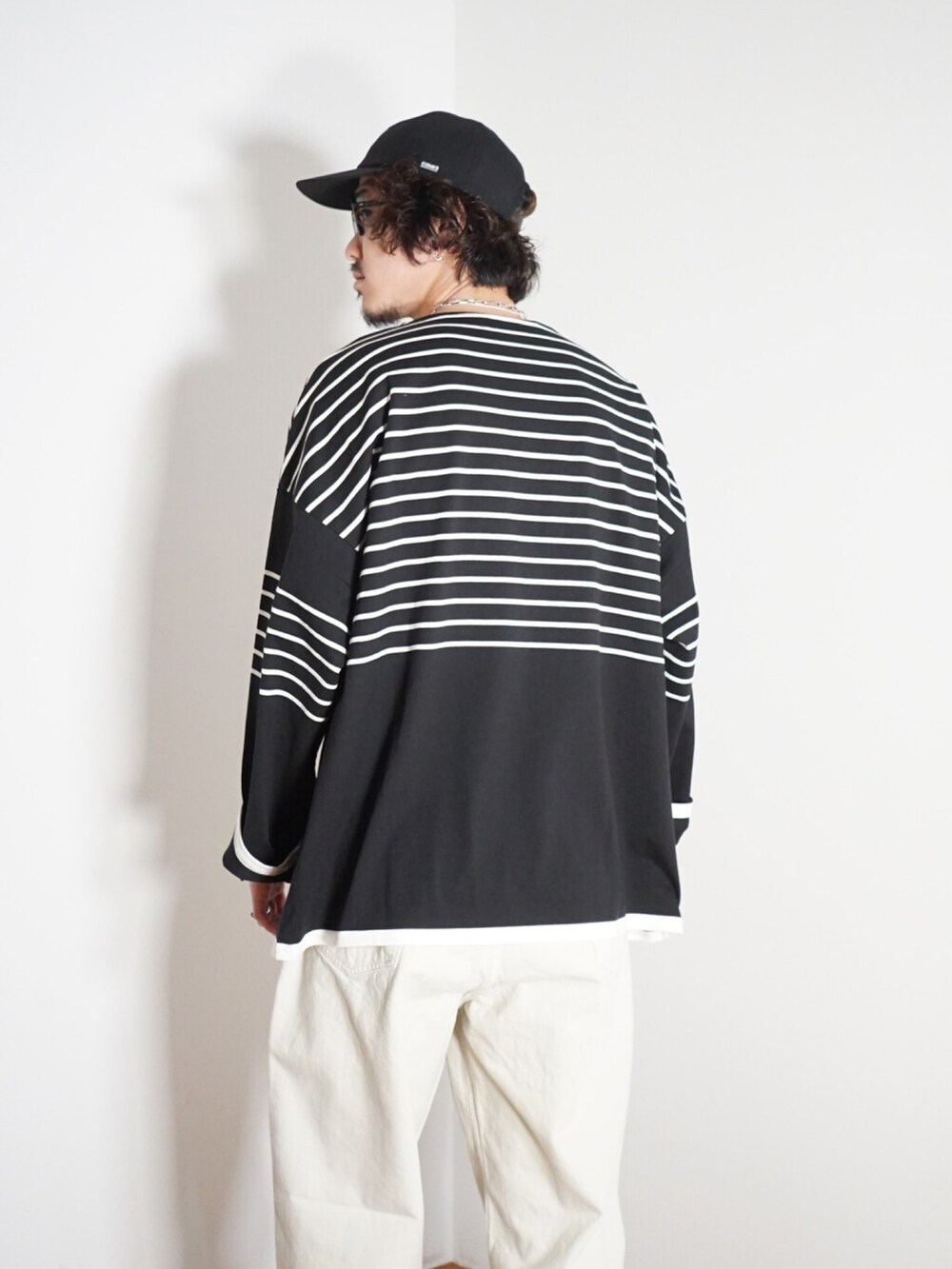 ブラック系のTシャツ/カットソー、ホワイト系のデニムパンツを着用したメンズの冬コーディネートの3枚目の写真