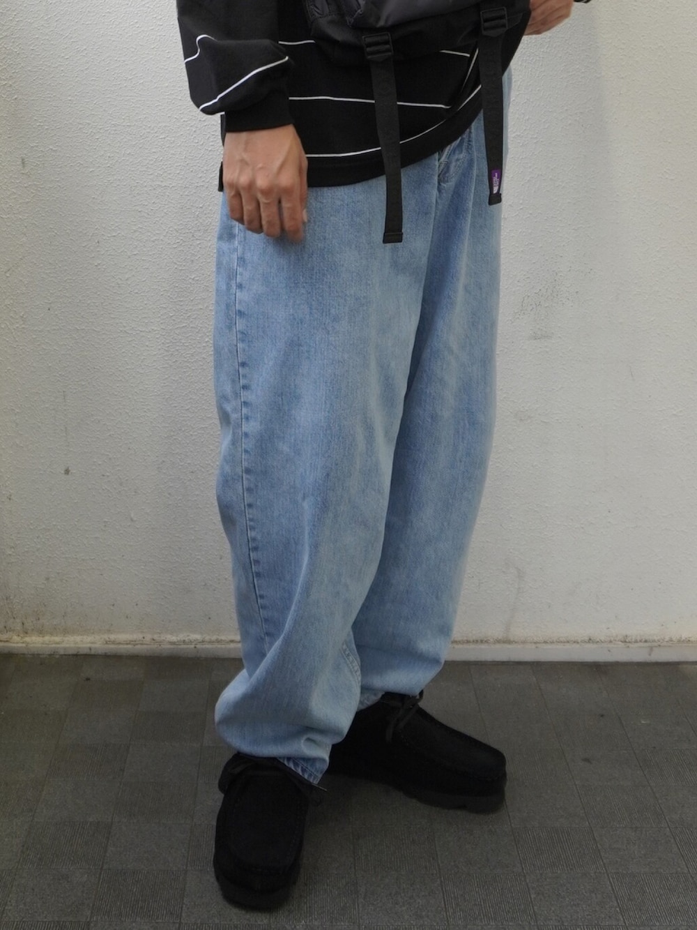 ブラック系のTシャツ/カットソー、ブラック系のショルダーバッグ、ブルー系のデニムパンツを着用したメンズの夏コーディネートの4枚目の写真