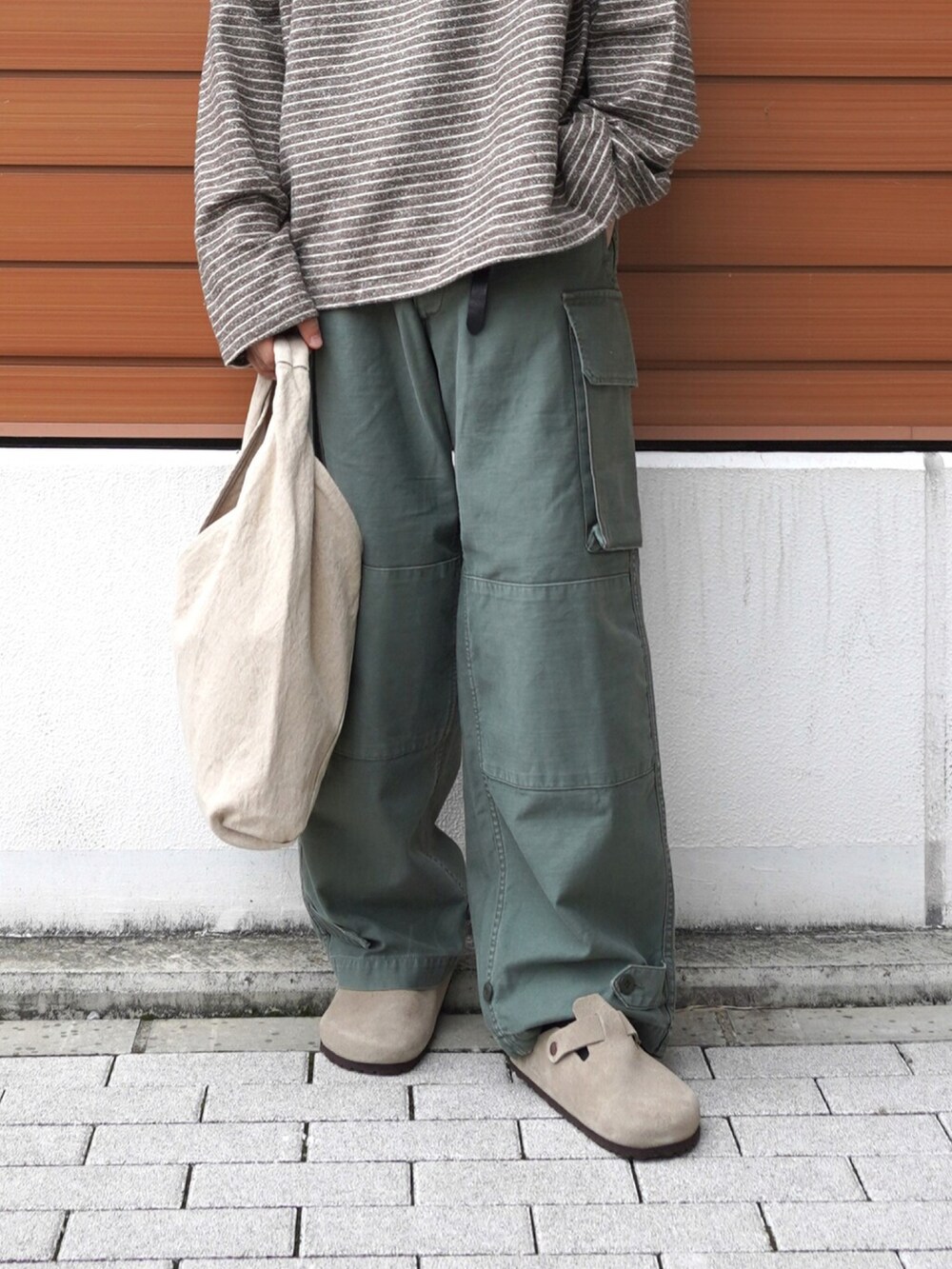 ブラウン系のTシャツ/カットソー、ベージュ系のハンドバッグ、その他のカーゴパンツを着用したメンズの秋コーディネートの2枚目の写真