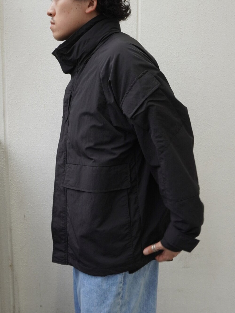 ブラック系のTシャツ/カットソー、ブラック系のショルダーバッグ、ブルー系のデニムパンツを着用したメンズの夏コーディネートの3枚目の写真