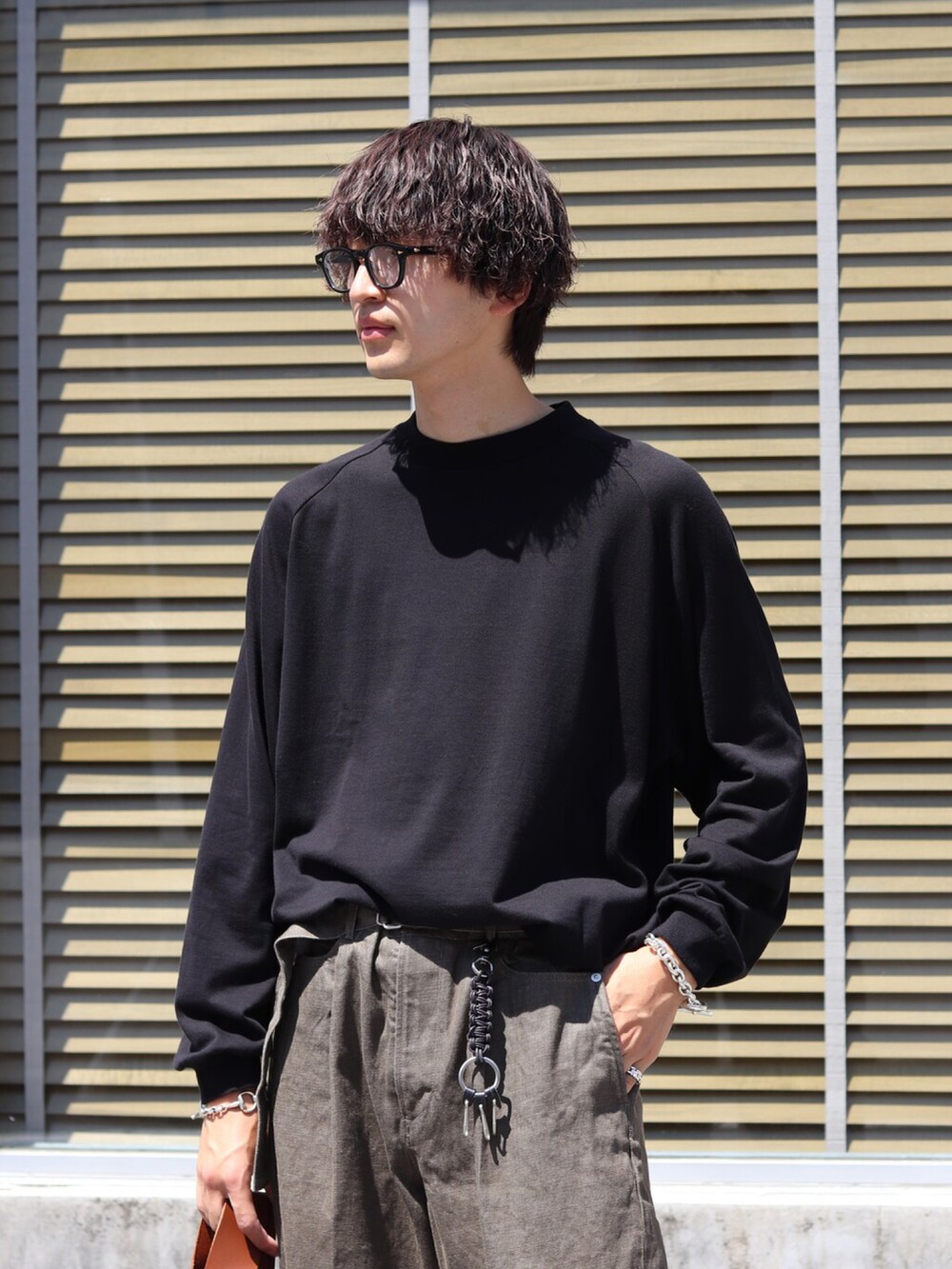 ブラック系のTシャツ/カットソー、グリーン系のカーゴパンツを着用したメンズの秋コーディネートの2枚目の写真