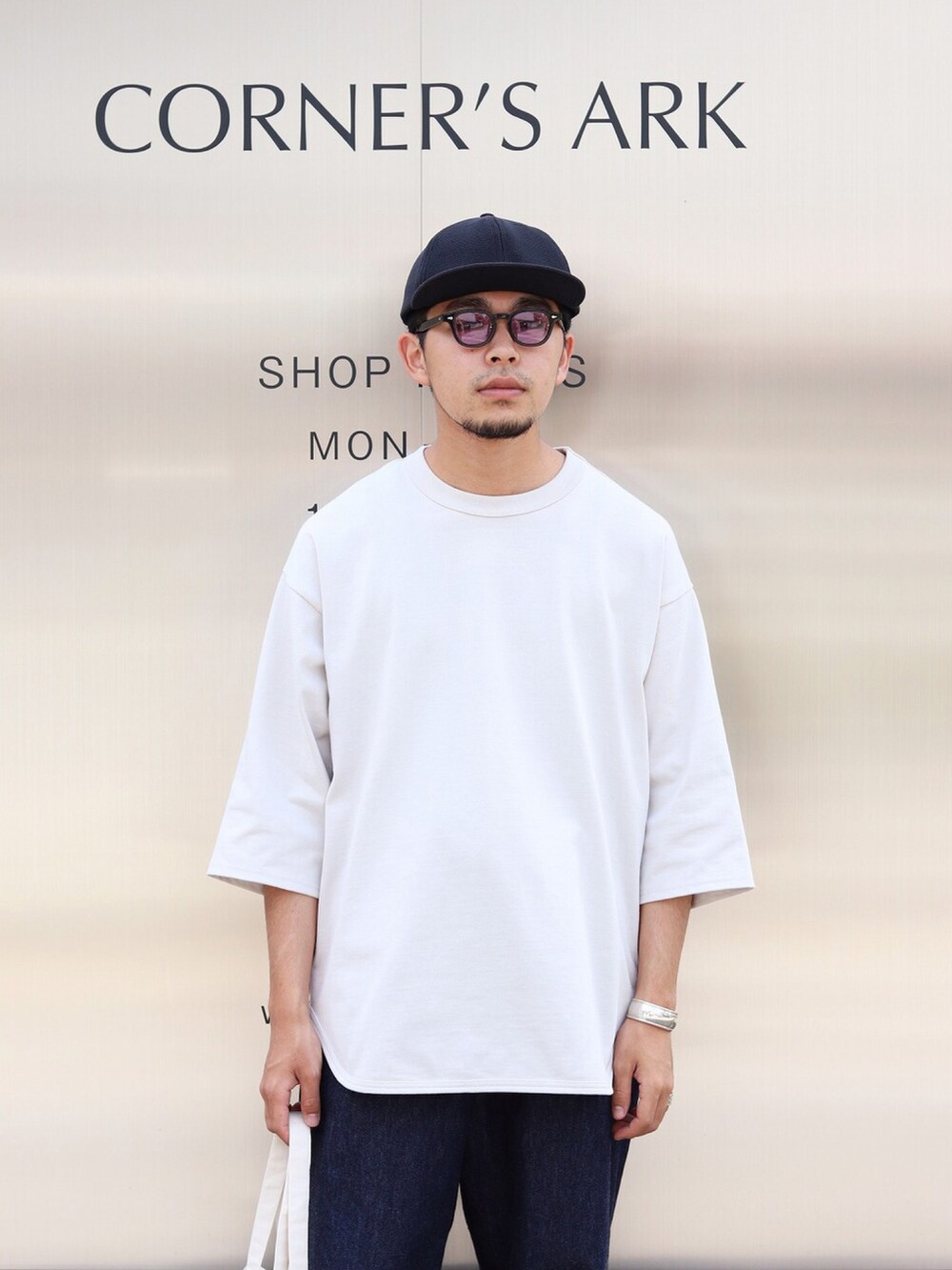 ホワイト系のTシャツ/カットソー、ブラック系のデニムパンツ、ホワイト系のトートバッグを着用したメンズの夏コーディネートの2枚目の写真