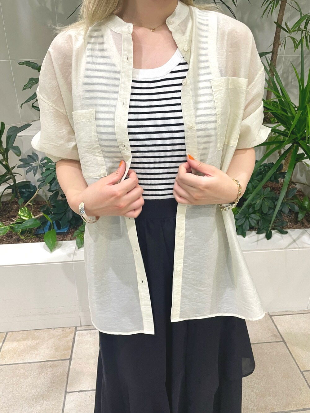 ホワイト系のタンクトップ、ホワイト系のシャツ/ブラウス、ブラック系のスカートを着用したレディースの夏コーディネートの4枚目の写真