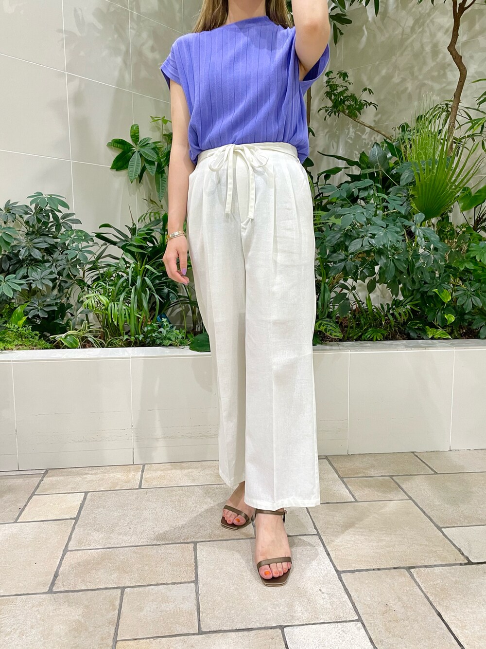 パープル系のニット/セーター、ホワイト系のその他パンツ、グリーン系のサンダルを着用したレディースの夏コーディネートの2枚目の写真