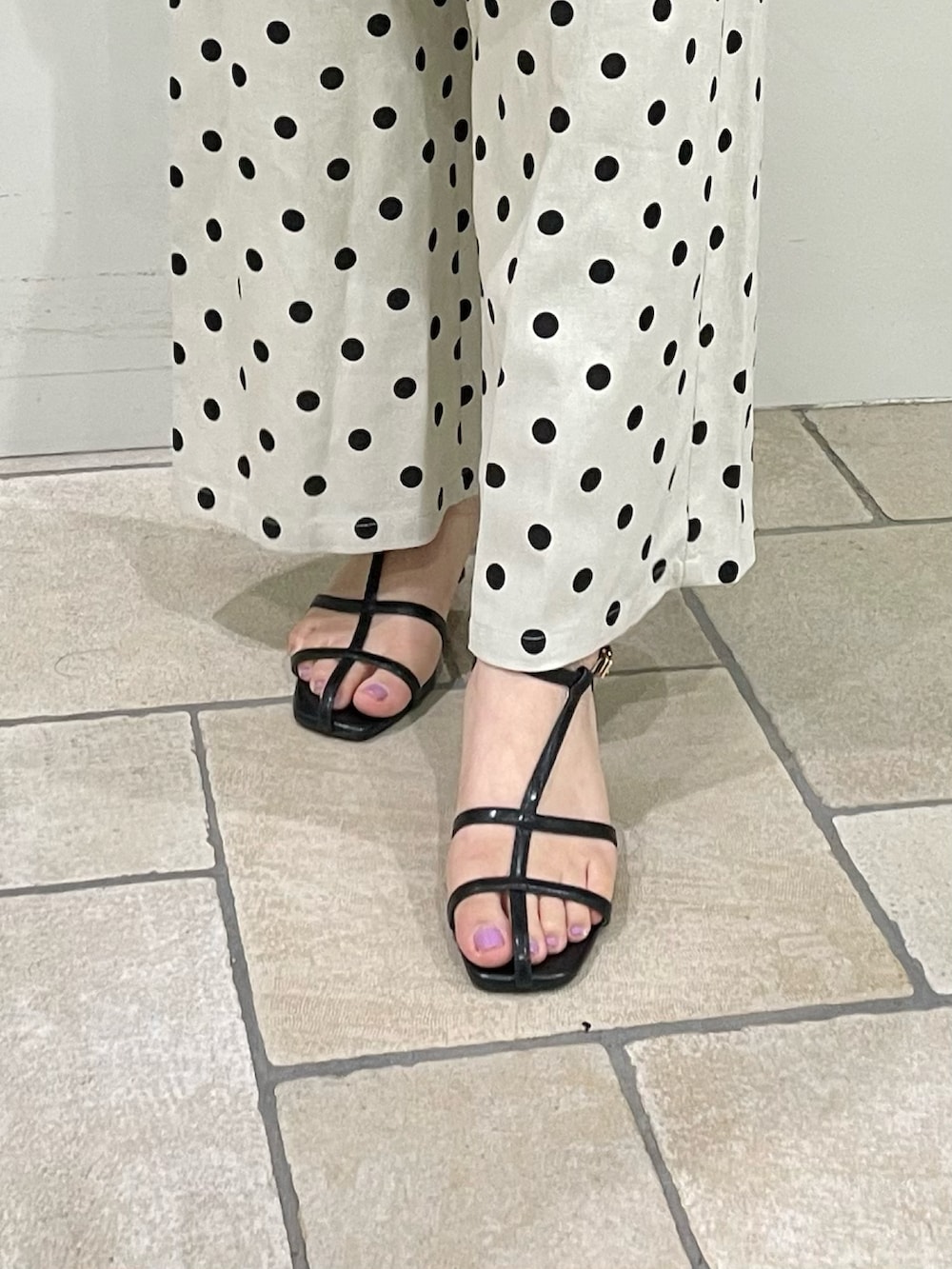 ブラック系のタンクトップ、イエロー系のカーディガン/ボレロ、ホワイト系のその他パンツを着用したレディースの夏コーディネートの5枚目の写真