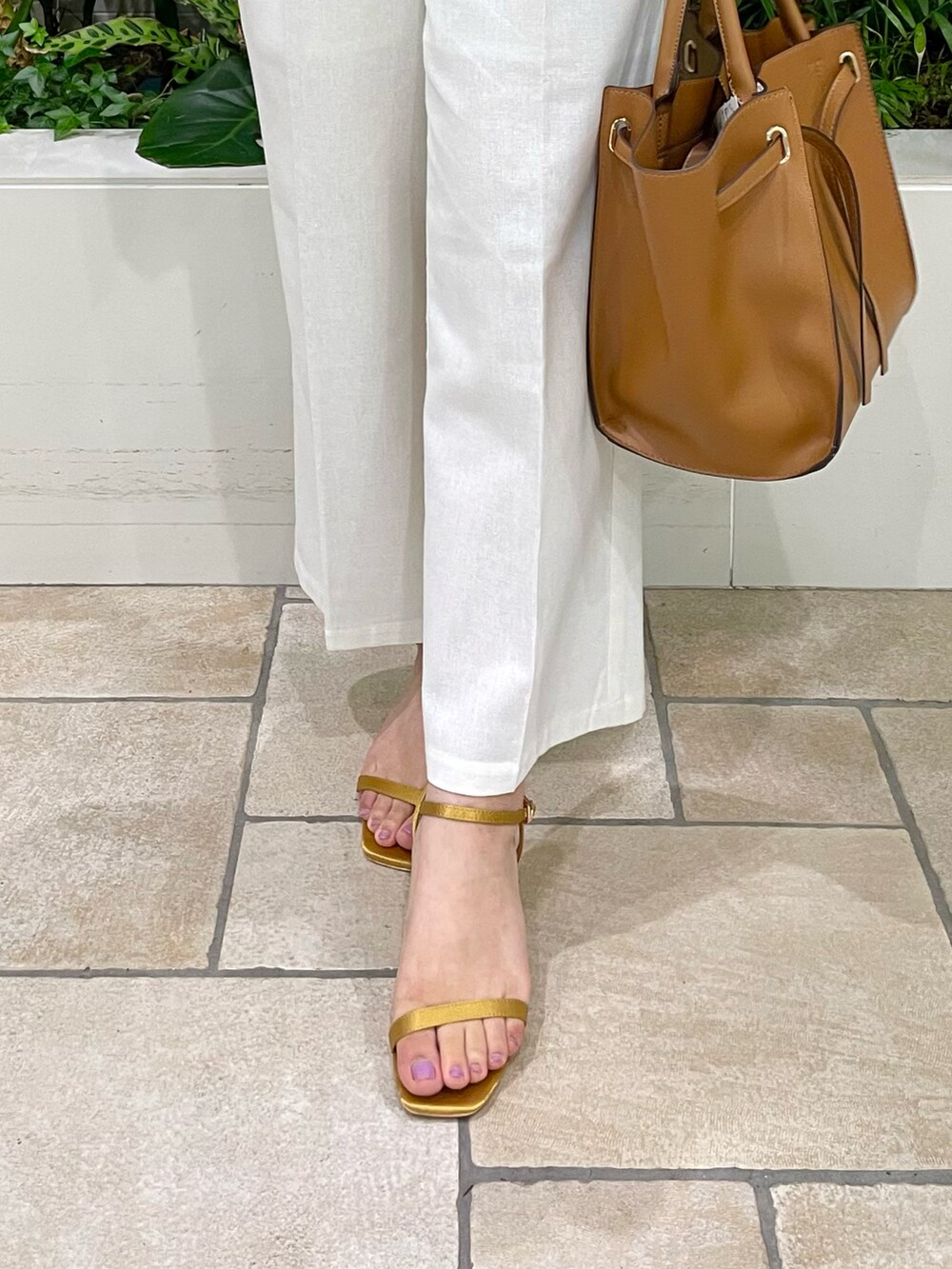 ブラウン系のバッグ、イエロー系のサンダル、ホワイト系のその他パンツを着用したレディースの夏コーディネートの4枚目の写真