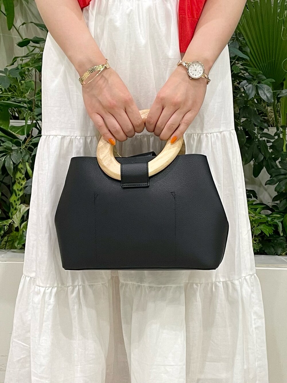 ブラック系のバッグ、ホワイト系のスカート、ホワイト系のTシャツ/カットソーを着用したレディースの春コーディネートの4枚目の写真