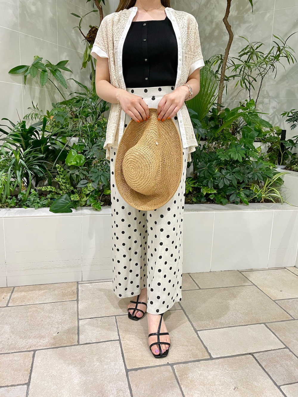 ブラック系のタンクトップ、イエロー系のカーディガン/ボレロ、ホワイト系のその他パンツを着用したレディースの夏コーディネートの4枚目の写真