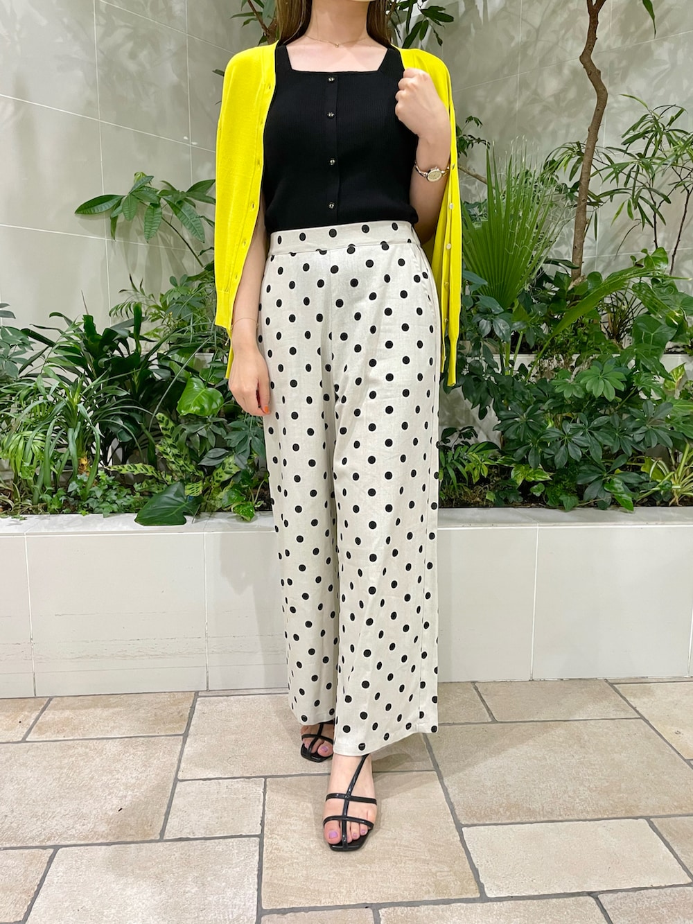 ブラック系のタンクトップ、イエロー系のカーディガン/ボレロ、ホワイト系のその他パンツを着用したレディースの夏コーディネートの2枚目の写真