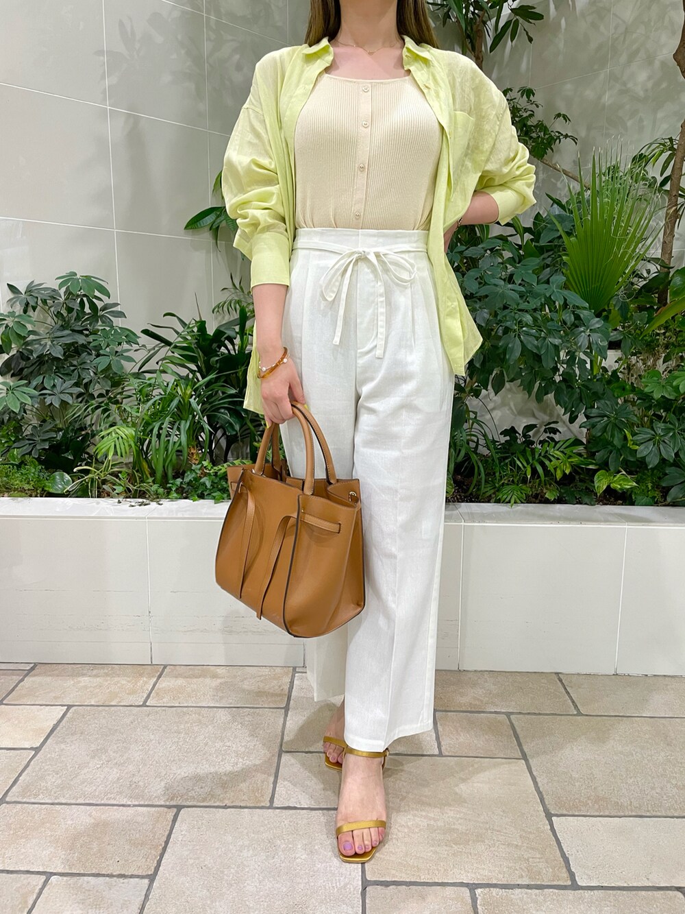 ブラウン系のバッグ、イエロー系のサンダル、ホワイト系のその他パンツを着用したレディースの夏コーディネートの2枚目の写真