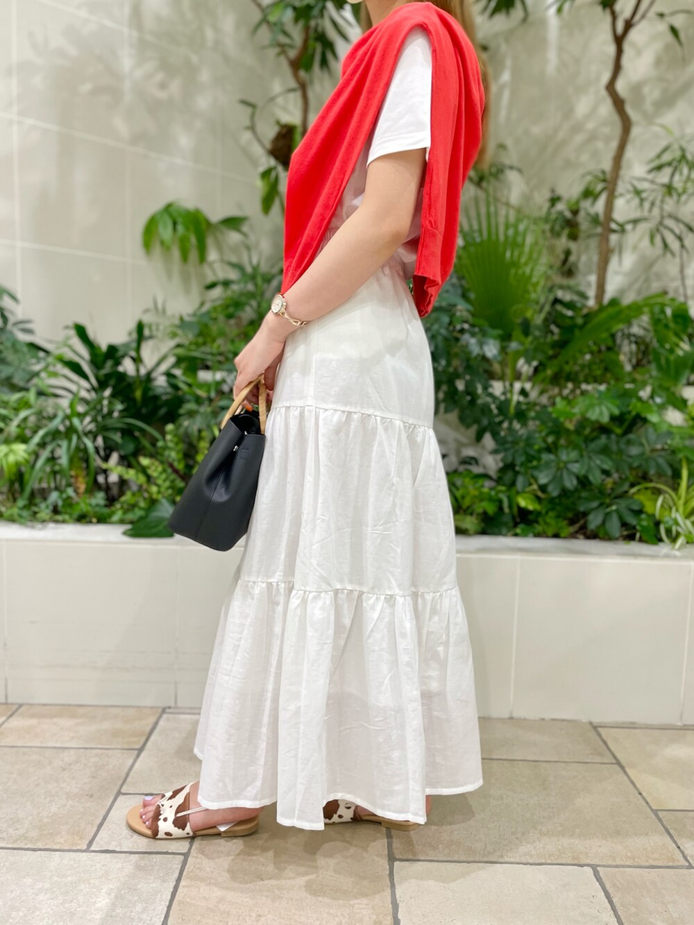 ブラック系のバッグ、ホワイト系のスカート、ホワイト系のTシャツ/カットソーを着用したレディースの春コーディネートの3枚目の写真