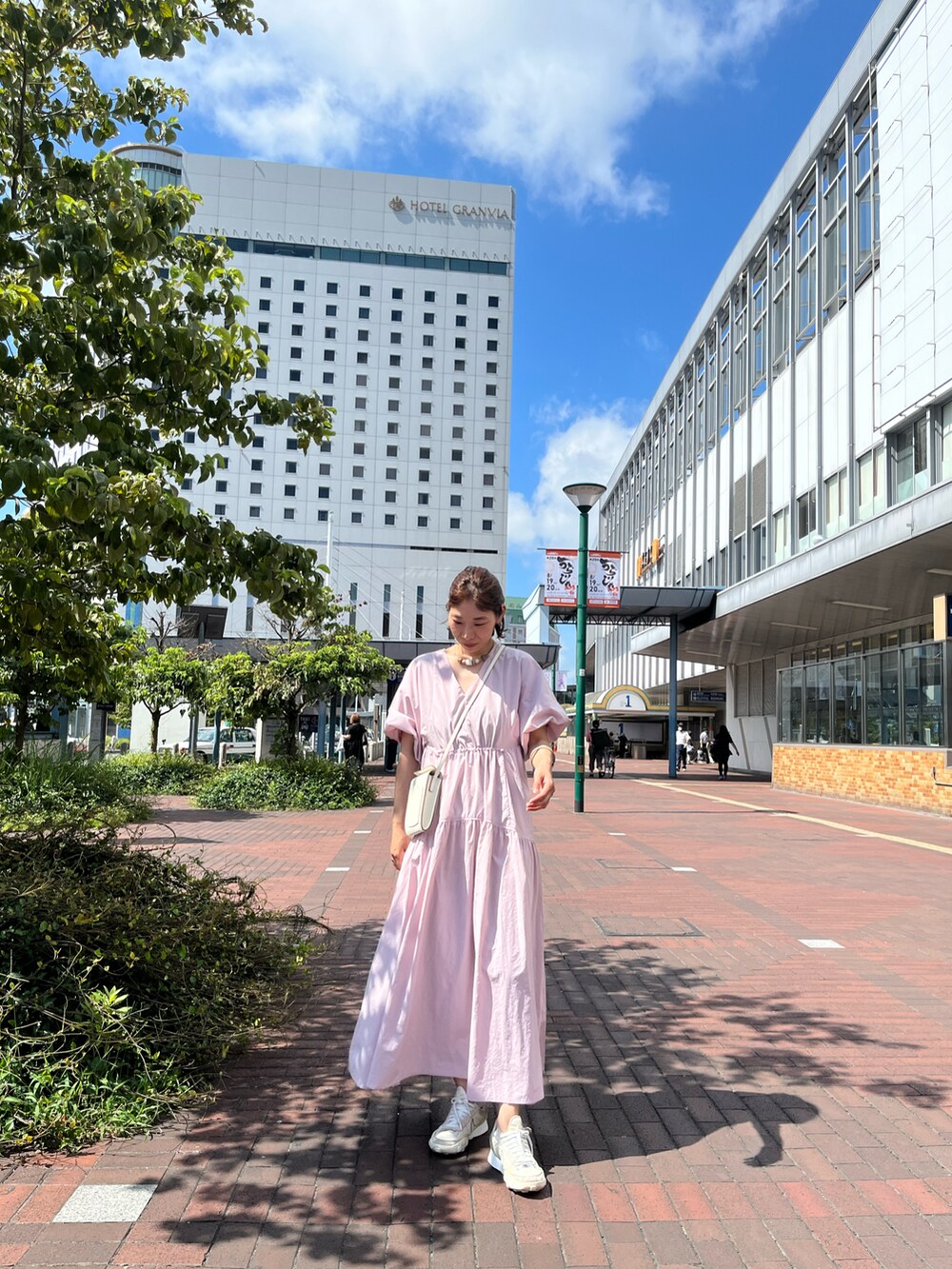 ピンク系のワンピース、ホワイト系のバッグを着用したレディースの夏コーディネートの2枚目の写真