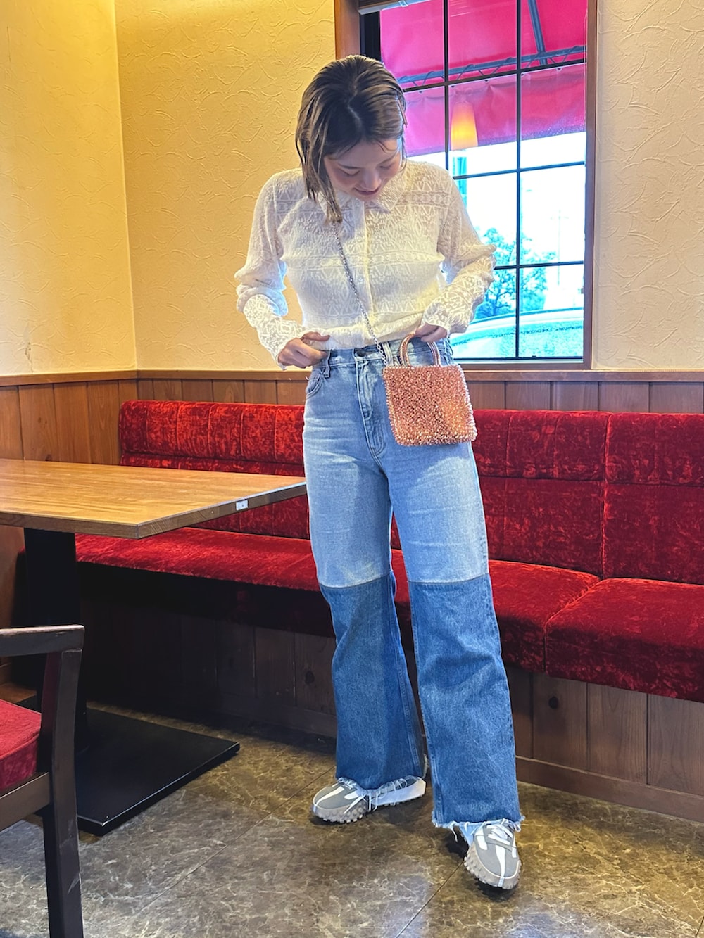 オレンジ系のバッグ、ブルー系のジャージ、グレー系のスニーカーを着用したレディースの春コーディネートの2枚目の写真