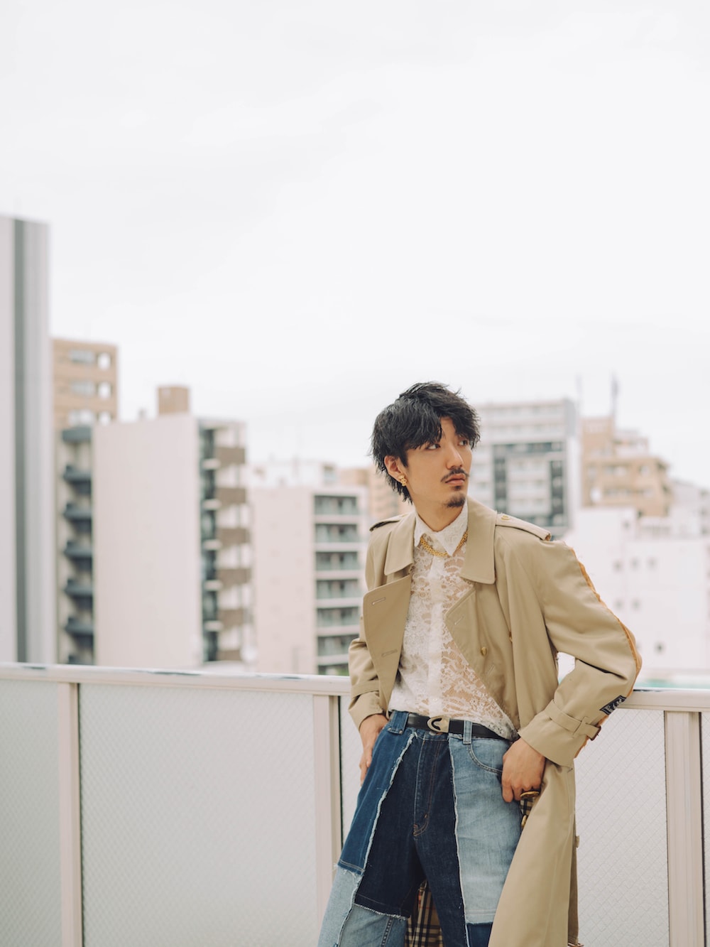 ベージュ系のトレンチコート、ブルー系のデニムパンツ、ブラウン系のローファーを着用したメンズの秋コーディネートの4枚目の写真