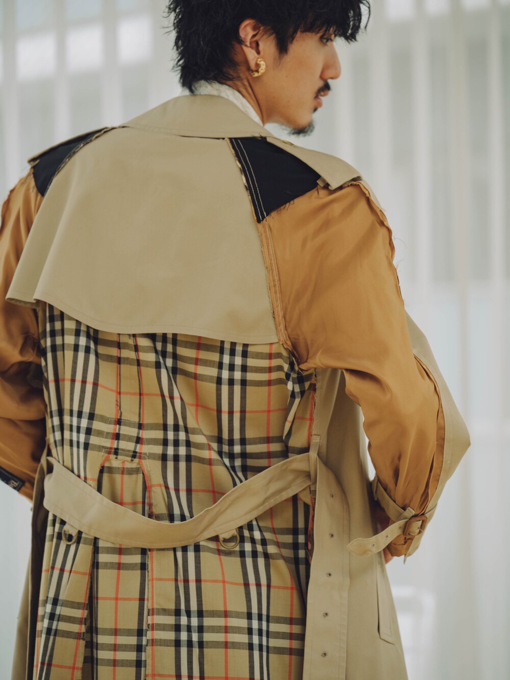 ベージュ系のトレンチコート、ブルー系のデニムパンツ、ブラウン系のローファーを着用したメンズの秋コーディネートの3枚目の写真