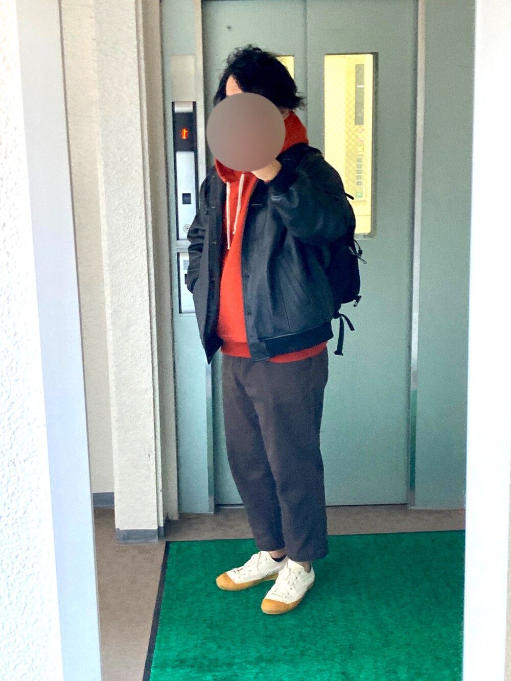 ブラウン系のパンツ、ホワイト系のスニーカー、レッド系のパーカーを着用したメンズの秋コーディネートの2枚目の写真