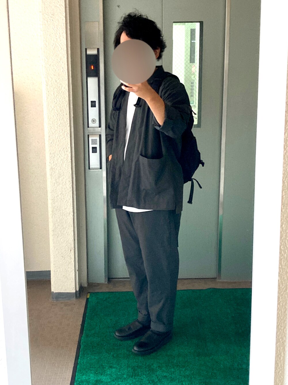 グレー系のパンツ、ブラック系のサンダル、ホワイト系のTシャツ/カットソーを着用したメンズの秋コーディネートの2枚目の写真