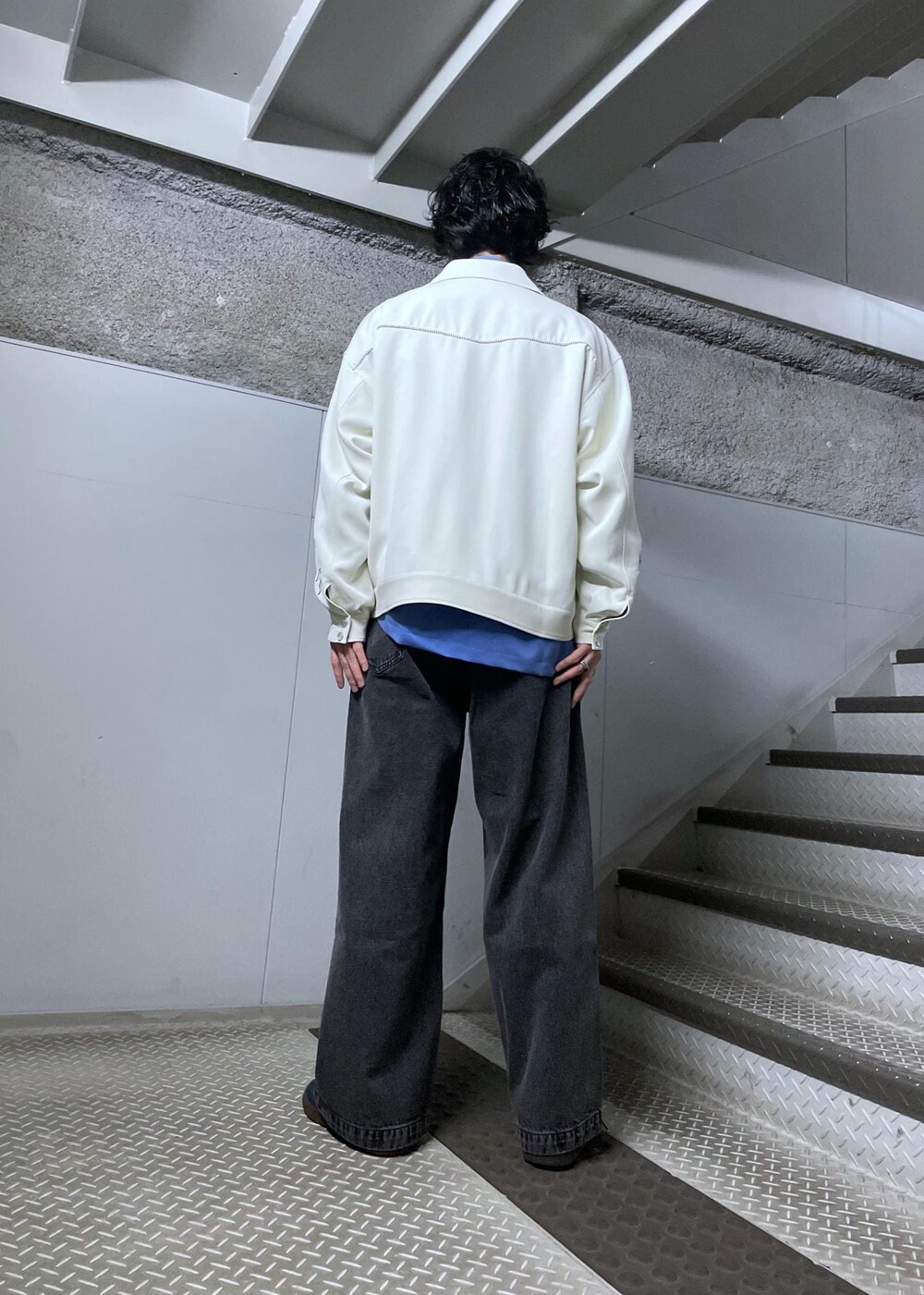 ホワイト系のブルゾン、ブラック系のデニムパンツ、ブルー系のシャツ/ブラウスを着用したメンズの冬コーディネートの3枚目の写真