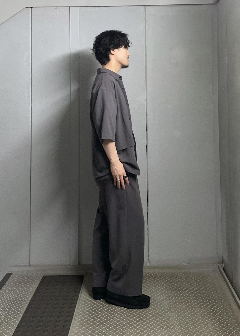 ブラック系のTシャツ/カットソー、グレー系のシャツ/ブラウス、グレー系のスラックスを着用したメンズの夏コーディネートの2枚目の写真