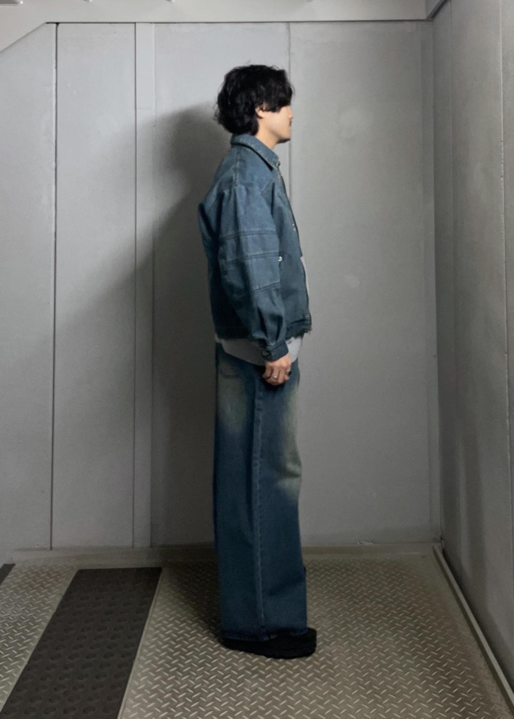 ブルー系のデニムパンツ、ブルー系のデニムジャケット、グレー系のニット/セーターを着用したメンズの冬コーディネートの2枚目の写真