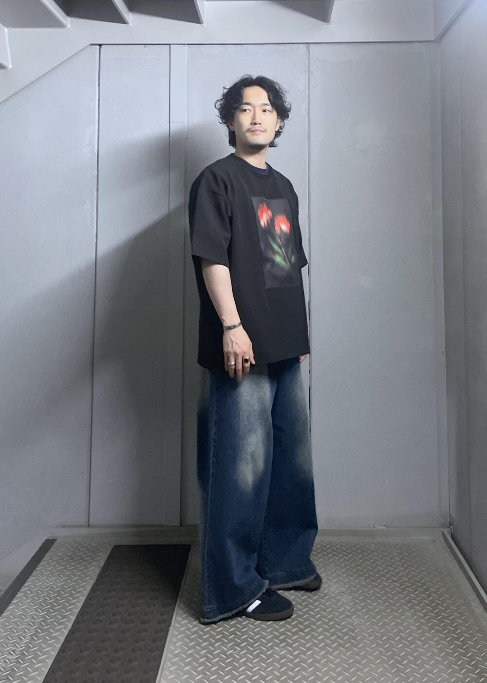 ブルー系のデニムパンツ、ブラック系のTシャツ/カットソーを着用したメンズの春コーディネートの4枚目の写真