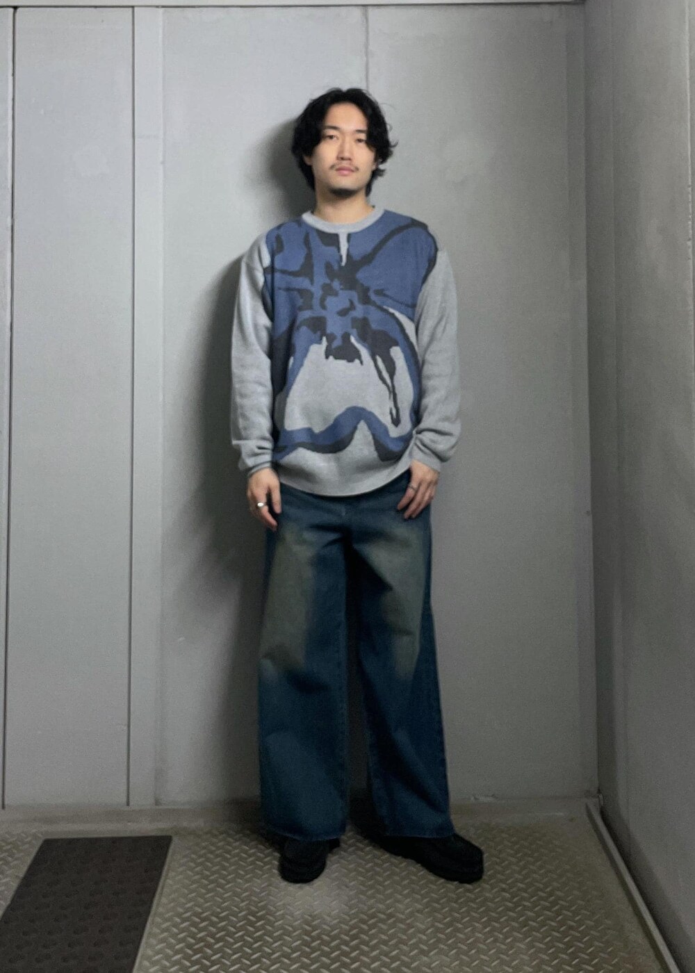 ブルー系のデニムパンツ、グレー系のニット/セーター、ホワイト系のシャツ/ブラウスを着用したメンズの冬コーディネートの8枚目の写真