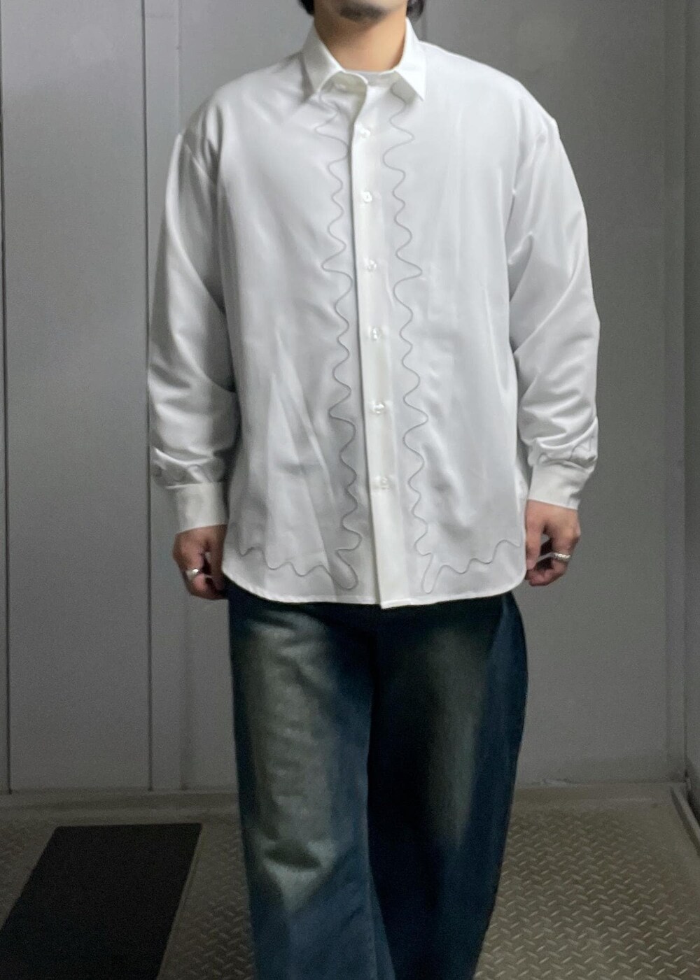 ブルー系のデニムパンツ、グレー系のニット/セーター、ホワイト系のシャツ/ブラウスを着用したメンズの冬コーディネートの6枚目の写真