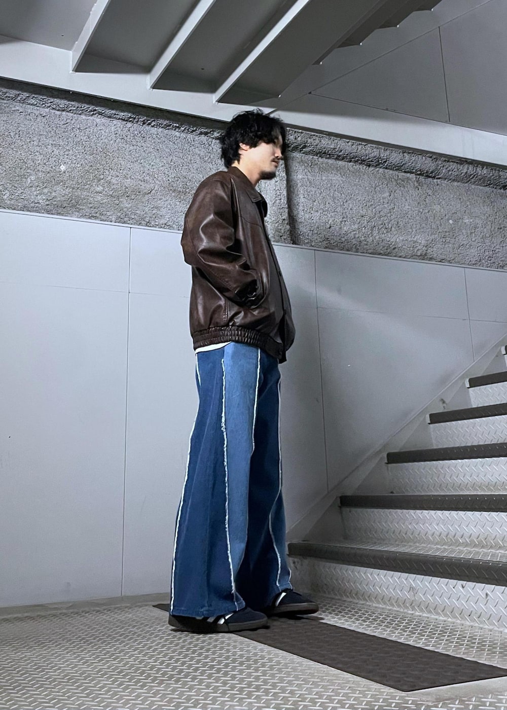 グレー系のスウェット、ブラウン系のブルゾンを着用したメンズの冬コーディネートの2枚目の写真